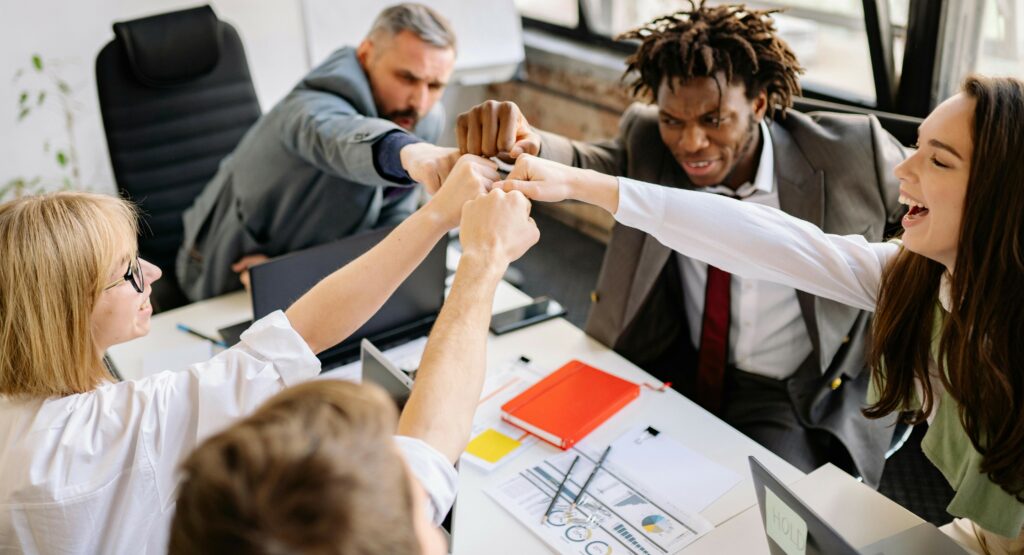 Une équipe diversifiée échangeant dans une atmosphère conviviale, symbolisant l'importance de la communication, de la reconnaissance et de l'équilibre vie professionnelle/vie personnelle pour prévenir l'usure mentale.