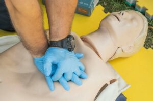 Employé en formation de Sauveteur Secouriste du Travail (SST) réalisant un geste de premiers secours lors d’un entraînement en entreprise.
